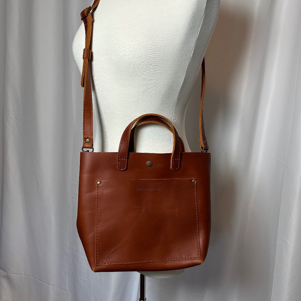 PORTLAND BROWN LEATHER TOTE W/HANDLES AND ADJUSTABLE STRAPS AND SNAP TOP CLOSURE